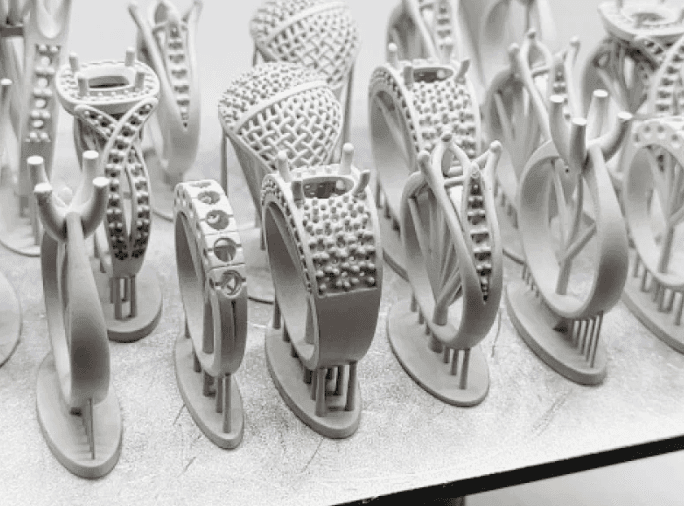 Close-up of 3D printed ring molds in various intricate designs arranged on a flat surface.